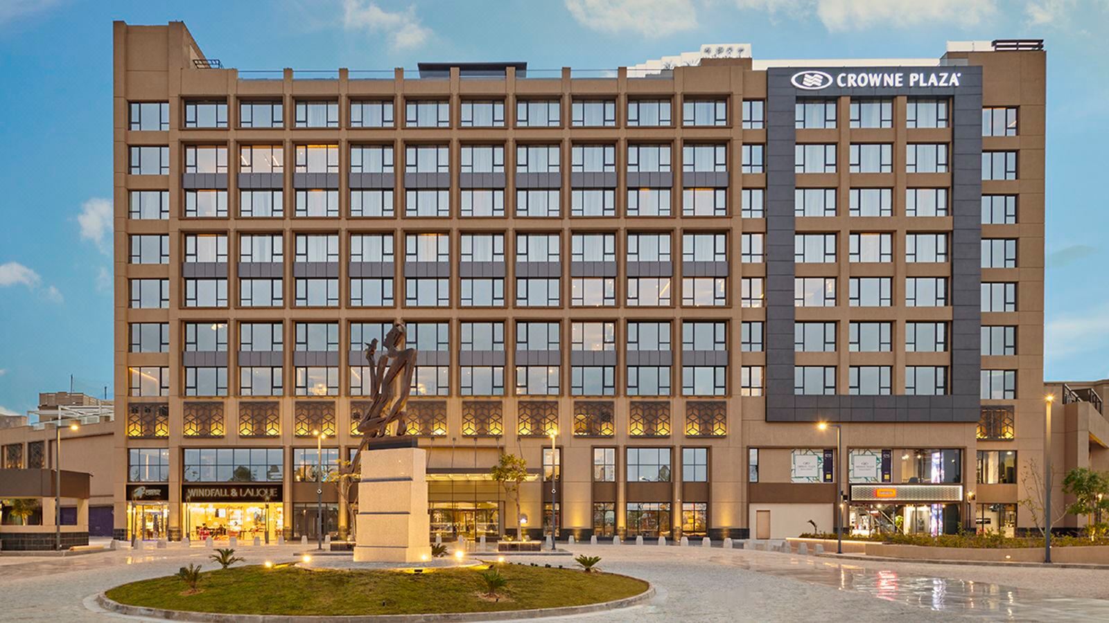 The illuminated exterior of Crowne Plaza West Cairo – Arkan at dusk.